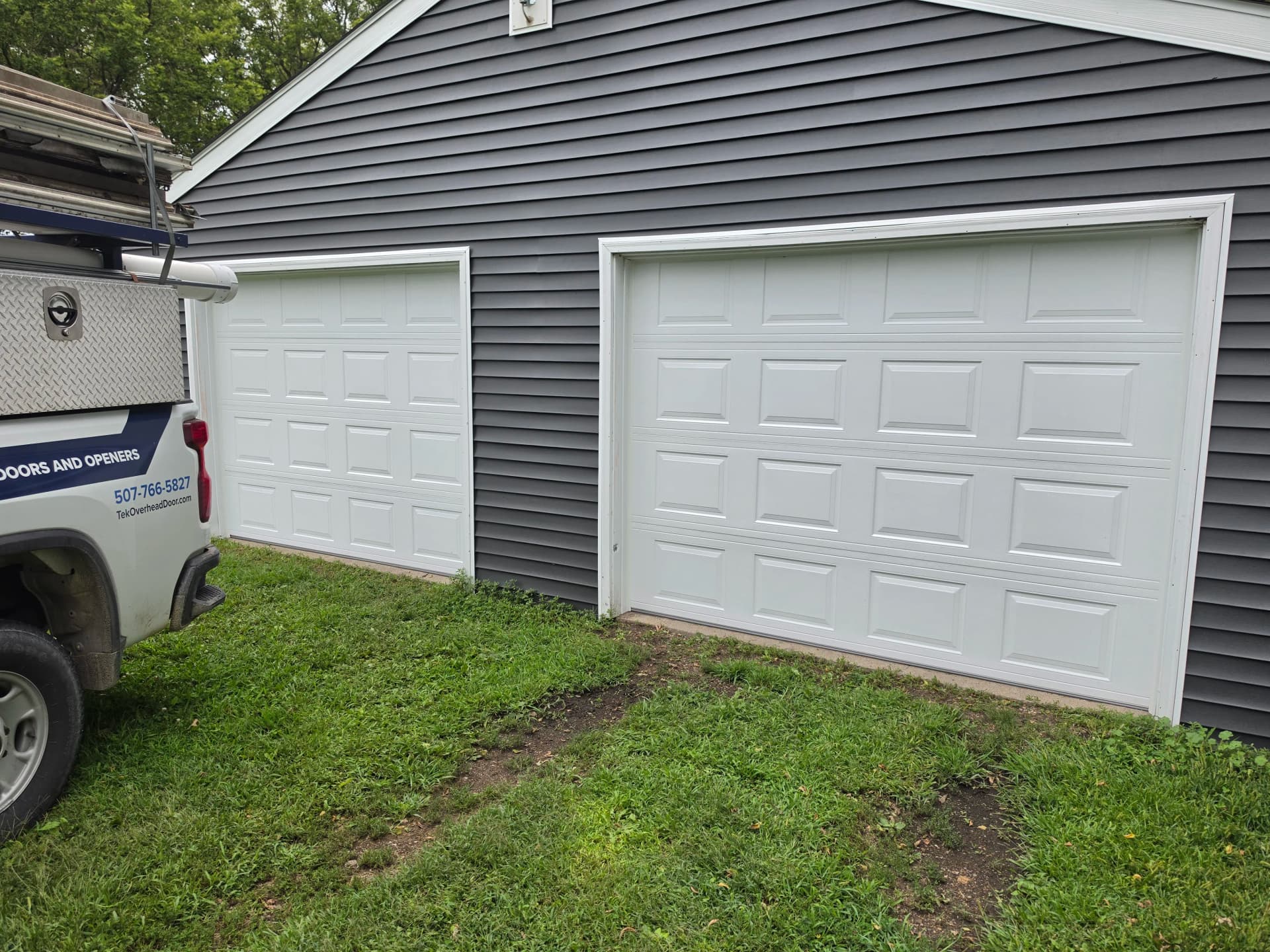 Two 9x7 White Raised-Panel Garage Doors Installed image
